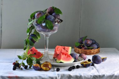 Ahşap arka planda olgun incir ve eriklerle dolu bir hayat