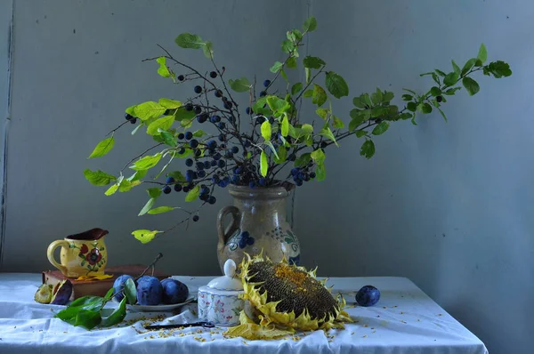 Mutfakta çiçekli bir hayat, çiçekli bir vazo vazo, bir vazo ve bir buket yabani üzüm.