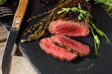 nadir barbekü biftek siyah angus bezelye filiz kekik biberiye baharat ile siyah dikdörtgen plaka üzerinde