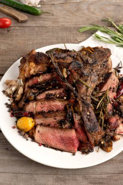 Gri ahşap arka planda az pişmiş biftek.