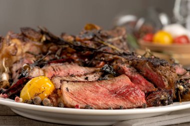 Az pişmiş biftek, yuvarlak tabak baharatları. Gri ahşap arka planda. Yakın plan.