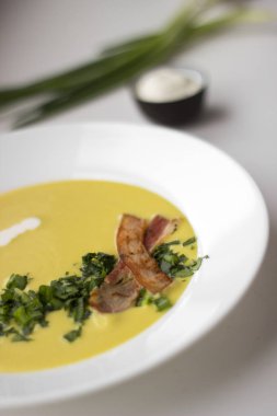 Bezelye çorbası domuz pastırması, maydanoz ve soğan bir kase parçaları ile bir 