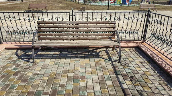 Dřevěná lavička v městském parku — Stock fotografie