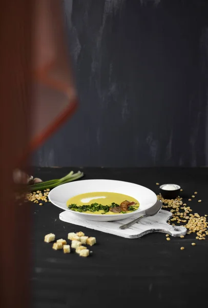 Bezelye çorbası domuz pastırması, maydanoz ve soğan bir kase parçaları ile bir 