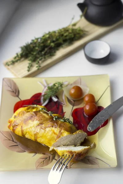 Poitrine de poulet cuite au four avec oignons et tomates sur une assiette blanche . — Photo