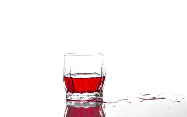 Всплеск красного сока, вино в стакане ребристого виски. — стоковое фото