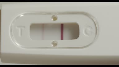 Pozitif gebelik testi elinde. Bir beyaz arka plan makro çekim izole