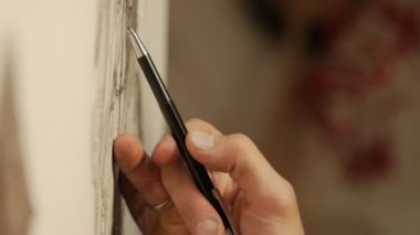 Adam sanatçı grafit kalemle çizer.