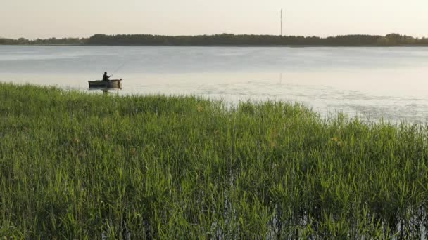 Pescador em um barco de pesca em um lago . — Vídeo de Stock