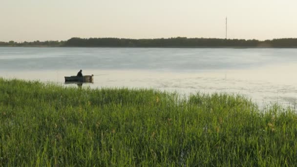 Pescador em um barco de pesca em um lago . — Vídeo de Stock