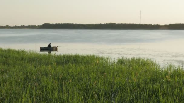 Visser in een boot te vissen op een meer. — Stockvideo