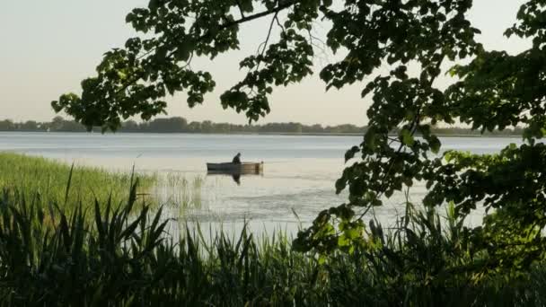 Fisherman in a boat fishing on a lake — Stock Video