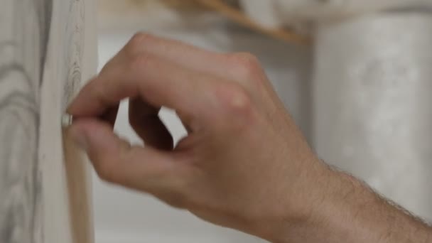 Männliche Finger löschen die Zeichnung auf einem weißen Blatt Papier. — Stockvideo