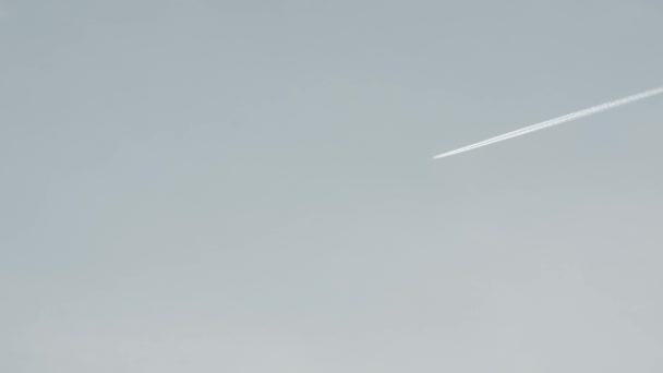 Вид на реактивный самолет, загрязнение неба воздушными судами, испарение белого траса днем — стоковое видео