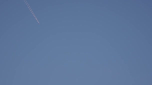 Contrain mavi gökyüzünde bırakarak uçan jet yolcu uçağı — Stok video