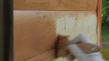 Bir fırça ile kahverengi renk ile ahşap boyama kapatın