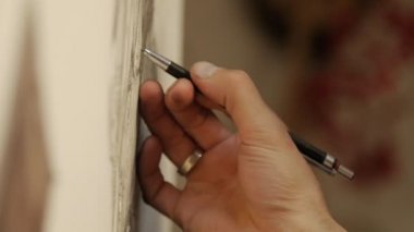 Adam sanatçı grafit kalemle çizer.