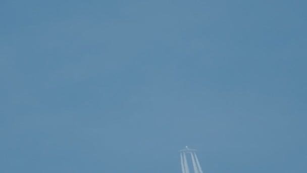 Самолет в полете, создавая белую полосу в голубом небе, называемую контрастом, конденсированной тропой или паром . — стоковое видео