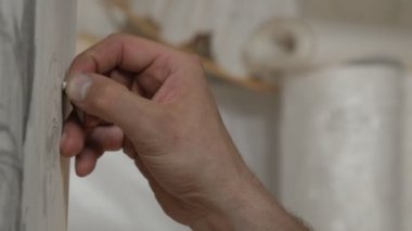 Erkek parmak silmek çizim bir beyaz kağıt levha.