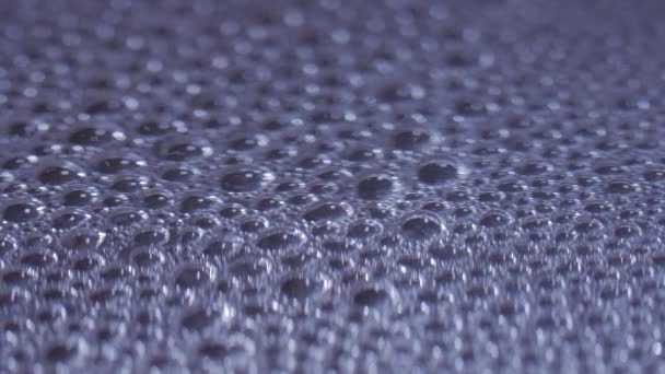 Bubbles of water boiling and evaporating in a black pan. Close up — Stock Video