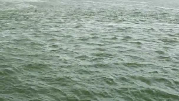 Gros plan de la surface ondulée du lac à la lumière du jour .