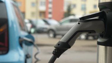 Şehir merkezini kapatırken elektrikli araba şarjı yakalıyor, sürdürülebilirlik ve teknolojik beceri birleştiriliyor.