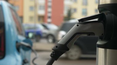 Yakından, gelişmiş bir EV şarj cihazı yenilenebilir gelişimi simgeleyen bir arabaya bağlanıyor..