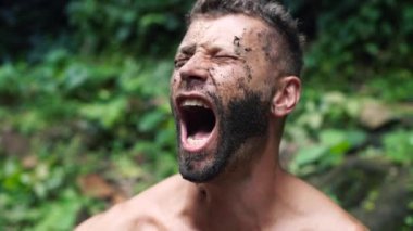 Vahşi bir ormanda 4k kirli yüzü ile genç yakışıklı çığlık adam yakın çekim