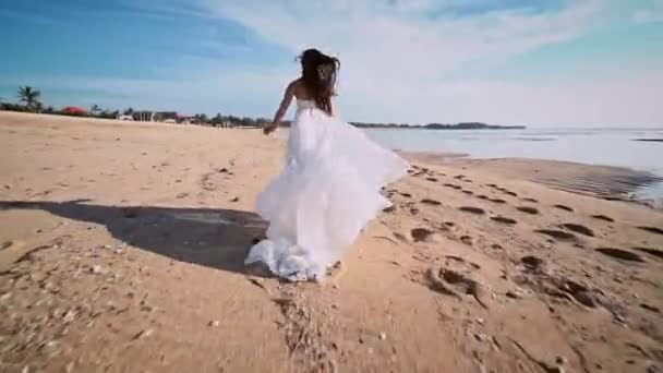 Ελκυστική Μελαχρινή Κορίτσι Μακρύ Λευκό Φόρεμα Τρέξιμο Στην Παραλία Ηλιοβασίλεμα — Αρχείο Βίντεο