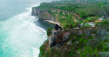 Uluwatu tapınağının havadan üst görünümü, Bali. Kayalar, kayalıklar, büyük dalgalar. Adanın en ünlü turistik yeri. 4k