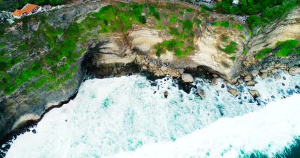 バリ島ウルワツ寺院の空中トップビュー。岩、崖、大きな波島で最も有名な観光地。4k — ストック動画