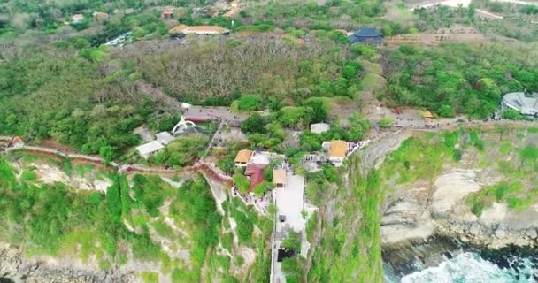 バリ島ウルワツ寺院の空中トップビュー。岩、崖、大きな波島で最も有名な観光地。4k — ストック動画