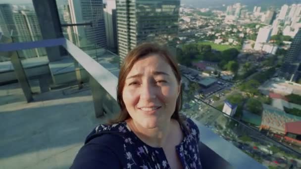쾌활한 주근깨 소녀는 현대 도시의 고층 건물의 높은 층에 이야기하고 서 온라인 비디오 채팅이 있습니다. Pov — 비디오