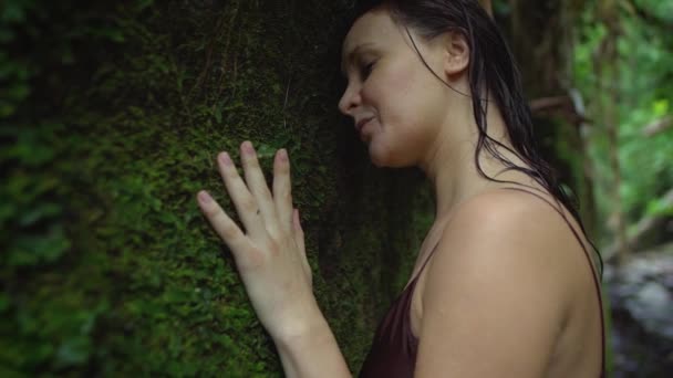 Die schöne schwangere Frau spürt Wehen und konzentriert sich nach dem Schwimmen im Fluss im tropischen Dschungel auf ihre Atmung. Zeitlupe. — Stockvideo