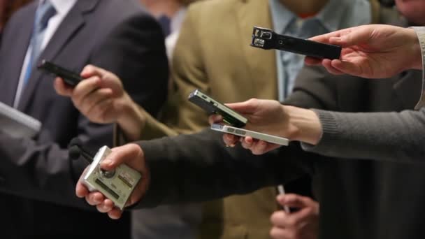 A group of unrecognizable journalists is recording an interview. They are holding dictaphones and notebooks. Conceptual background frames about journalism and the media. — Stock Video