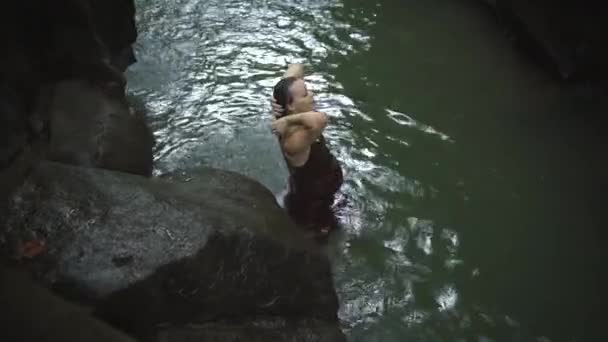 Vacker gravid kvinna i en mörkbrun klänning bada i tropiska djungeln floden. Slow motion. — Stockvideo