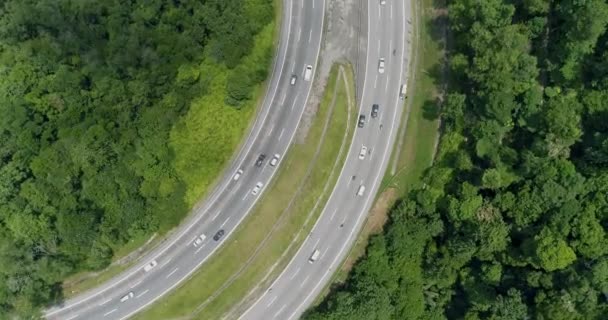 Widok z lotu ptaka na dwie autostrady z nadjeżdżających ruchem wśród zielonych lasów 4K — Wideo stockowe