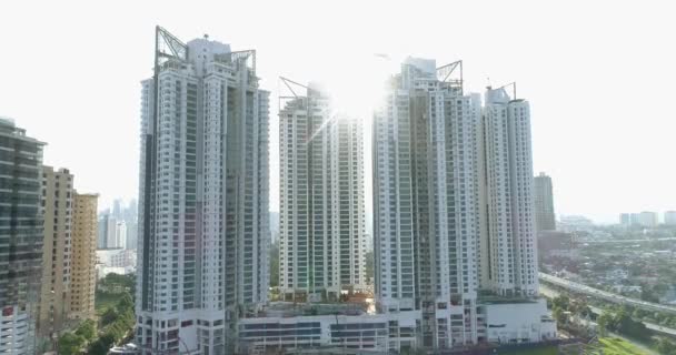 Аэросъемка новых многоэтажных жилых домов, строящихся в Куала-Лумпуре. Между домами ярко светят солнечные лучи. 4K — стоковое видео