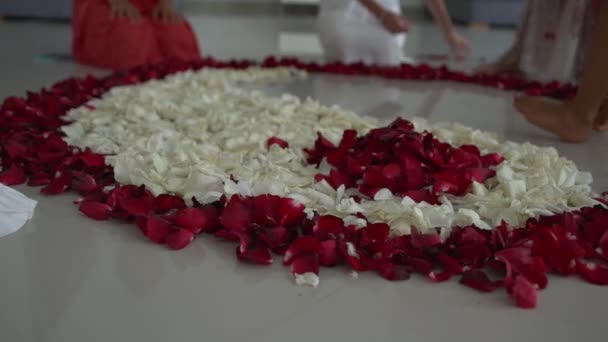Жіночі руки створити Мандала з пелюстками троянд у формі Інь Янь символ — стокове відео