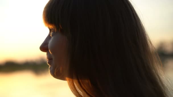 Joven mujer bonita sola al atardecer, mirando al cielo, sonriendo tímidamente, soledad — Vídeos de Stock