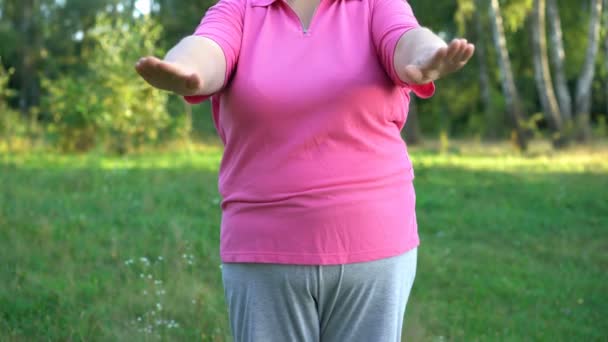 Primer plano de la mujer con sobrepeso haciendo ejercicio en el brazo, pérdida de peso, entrenamiento en el parque — Vídeo de stock