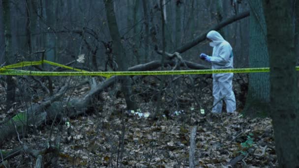 Crime scene, lab analyst in protective gear collecting data and evidence at site — Stock Video