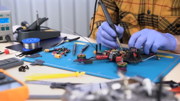 Mühendis, insansız hava aracı parçalarını tamir etmek, bakım, onarım için lehim demiri kullanıyor. Hobi — Stok video