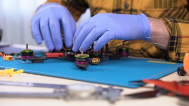 Elektronik tamir, bakım merkezi. Bir yarış drone üzerinde çalışan teknisyen