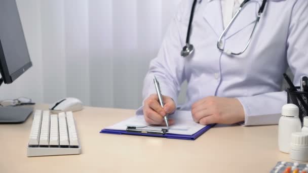 Doctor taking notes, filling out medical papers, keeping records in their office — Stock Video