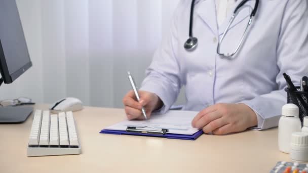 Tıp doktoru raporu bitirip imzalıyor, ofisinde çalışan doktor — Stok video