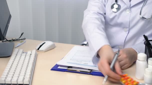Médico anotando el diagnóstico y trabajando en el plan de tratamiento, llenando formularios — Vídeos de Stock