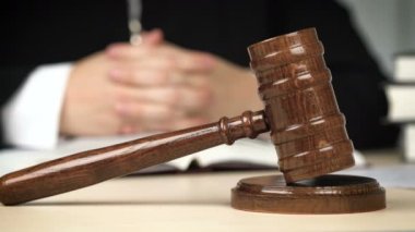 Yargıç mahkeme salonunda masa başında oturuyor, hukuku temsil ediyor, adaleti yönetiyor.