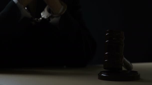 Наручники судья положить руки на стол рядом с молотком, коррупция, взяточничество — стоковое видео