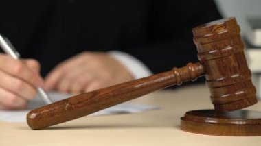 Hakim veya müzayedeci formları doldurarak, mahkeme salonunda masada kağıtları imzalama